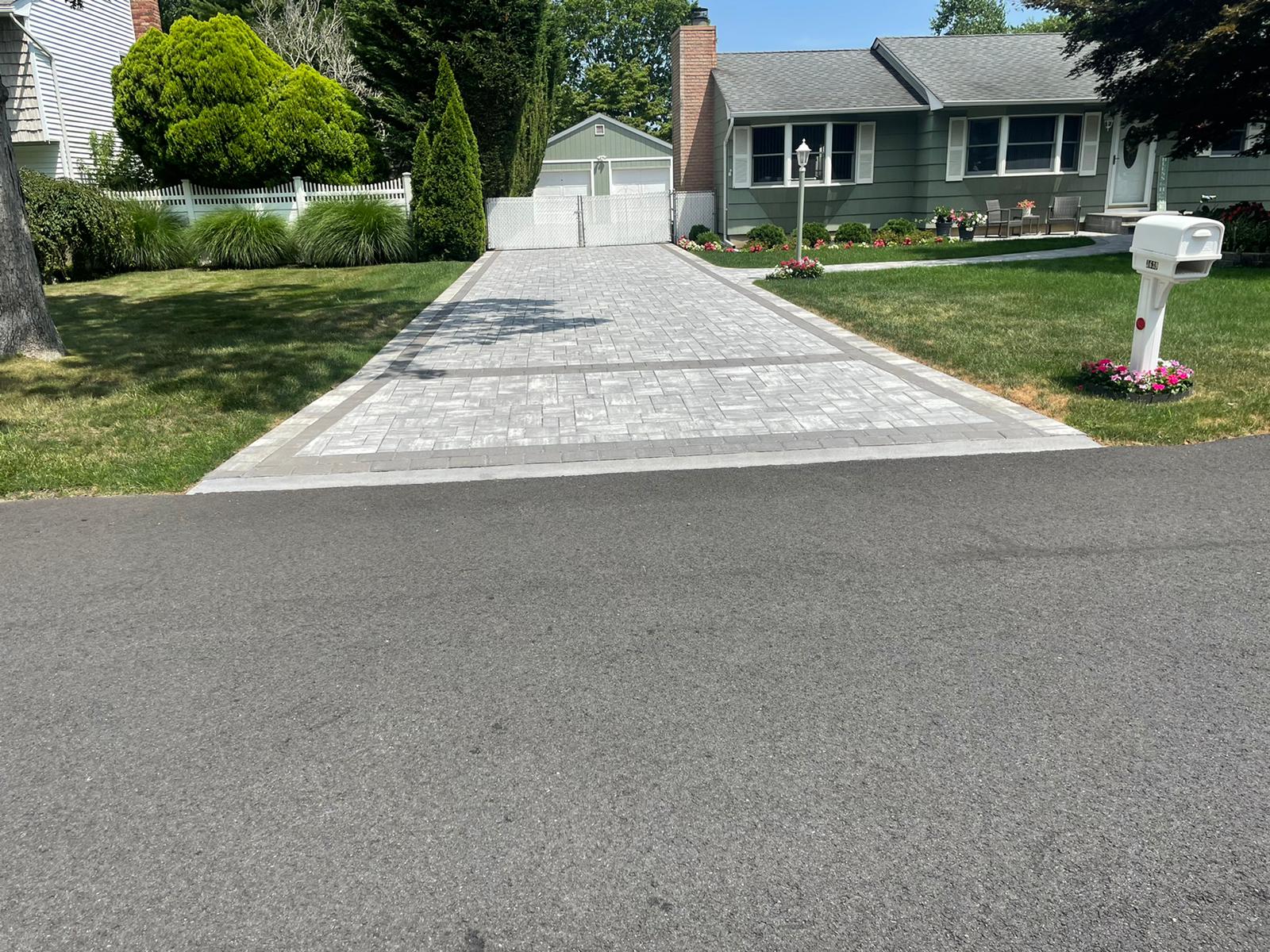 Light gray paver driveway with a contrasting soldier-course border