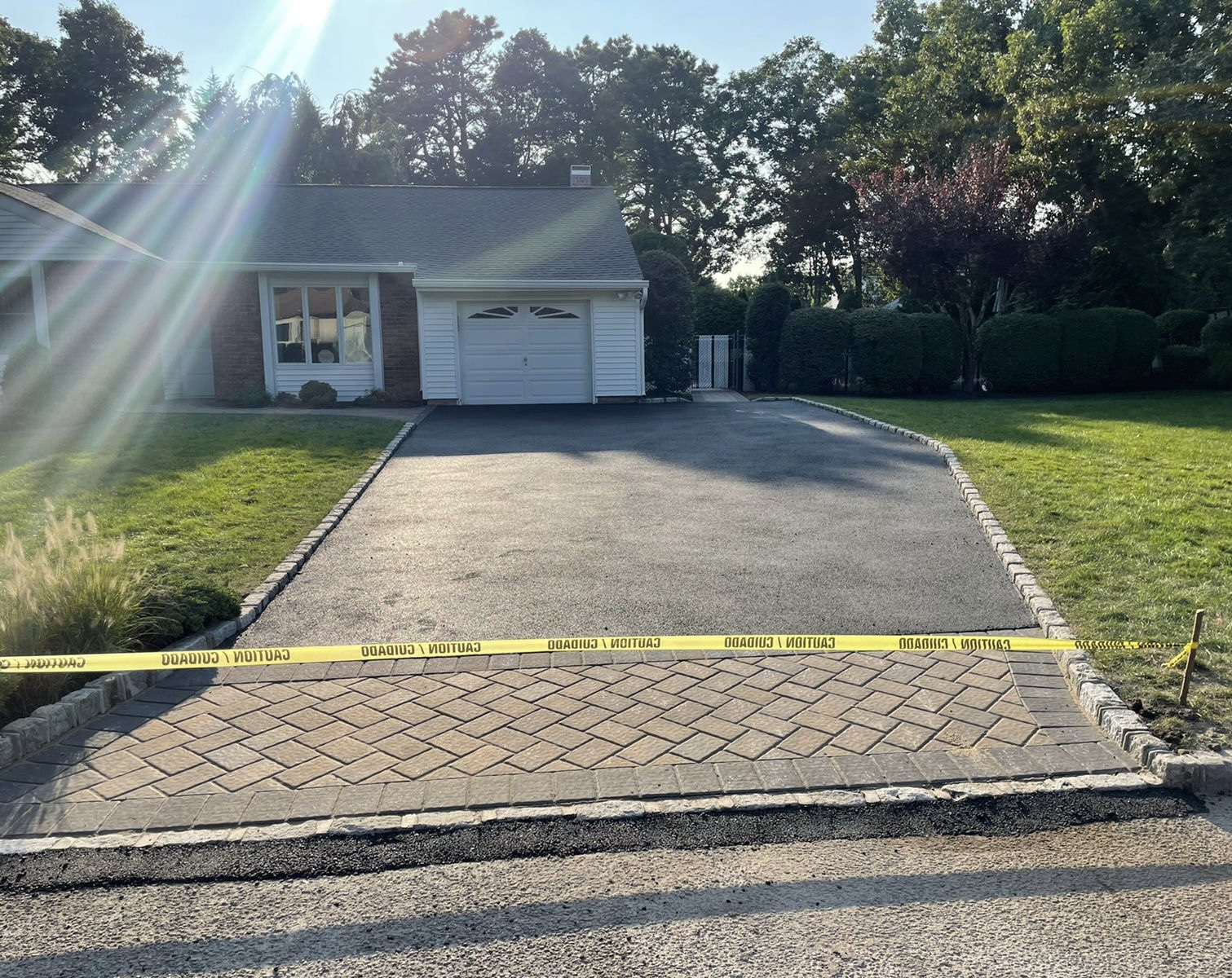 Asphalt driveway with a herringbone paver apron and Belgian block border