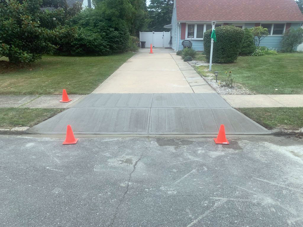 New concrete driveway apron and sidewalk poured at the curb line