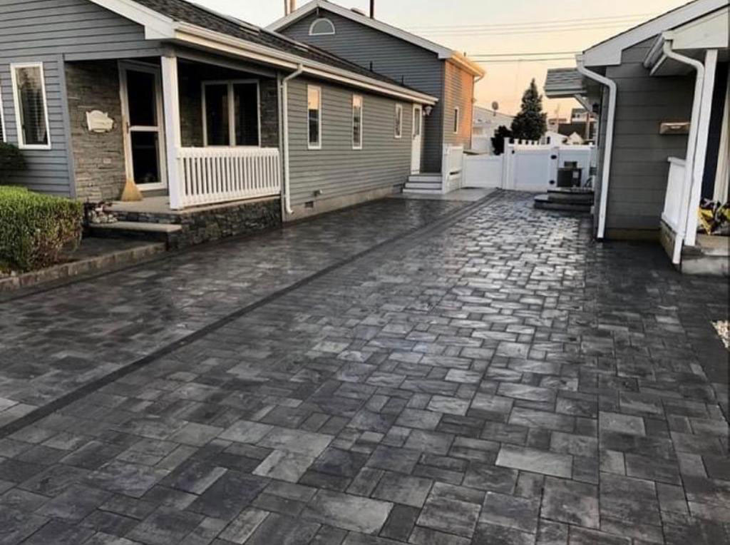 Charcoal paver driveway running between two homes